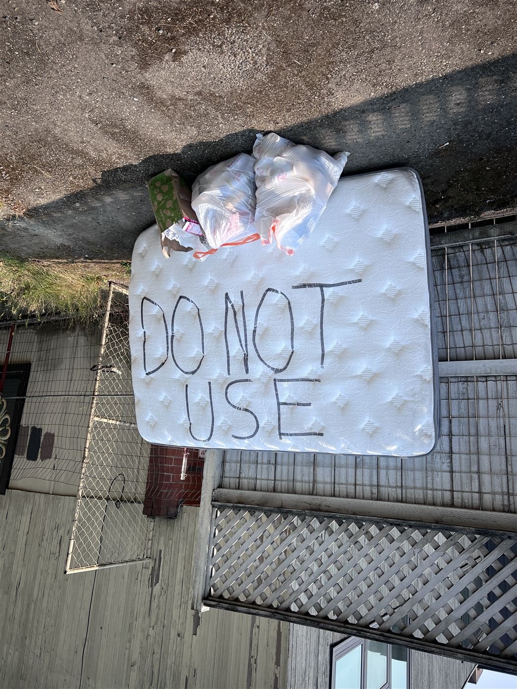 Mattress and bags set curbside for pickup