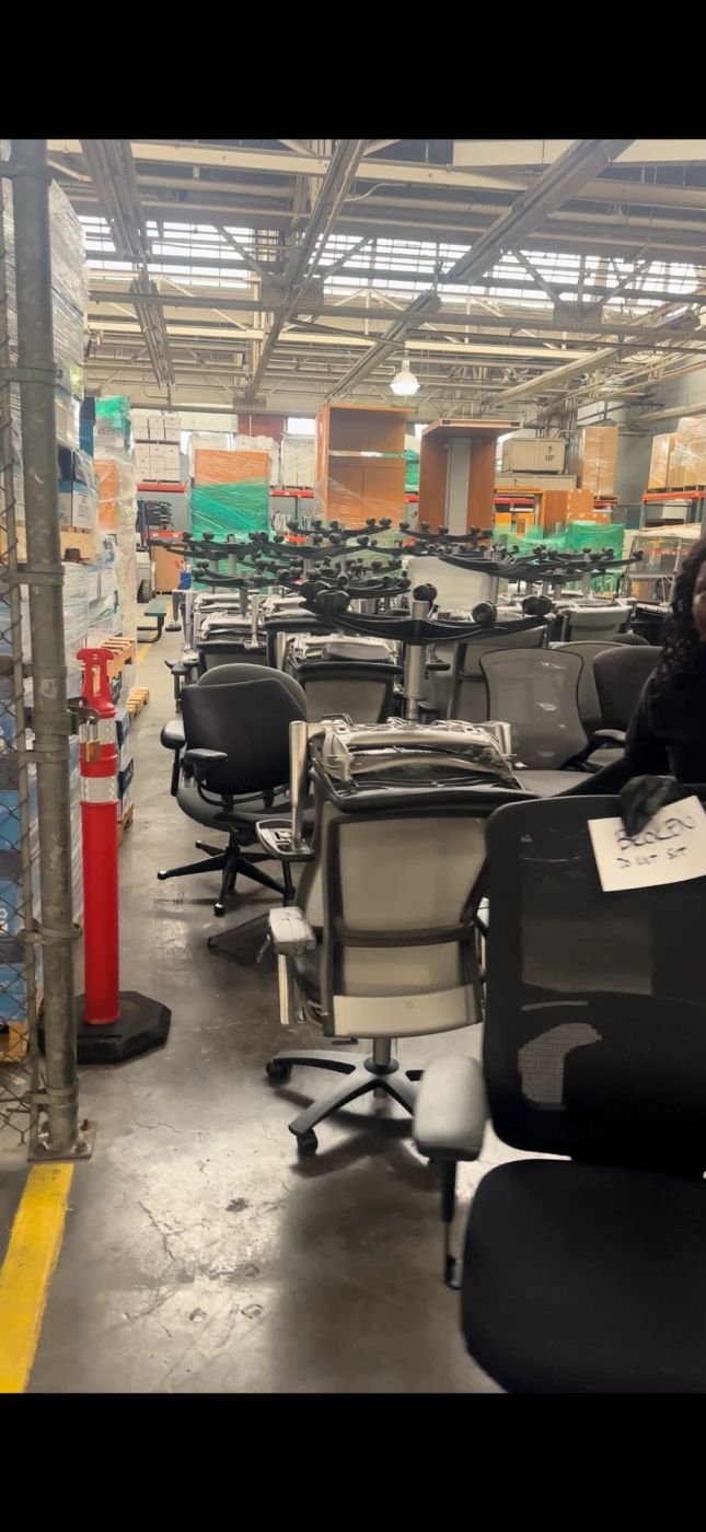 Rows of office chairs staged for removal in a warehouse